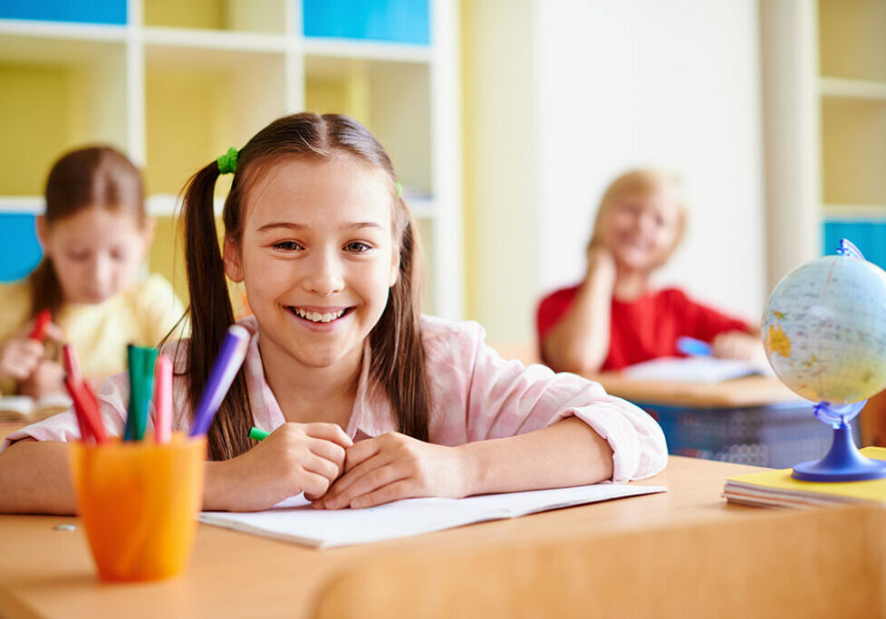 Portrait of lovely girl looking at camera at lesson of drawing